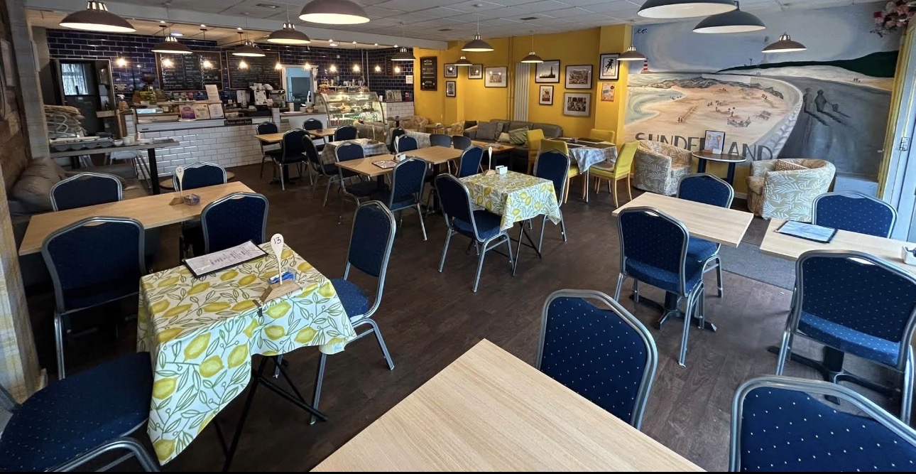 The newly decorated interior of Oscars Coffee House with yellow walls, blue chairs and the Sunderland seafront mural